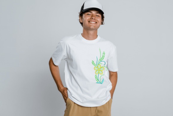 Young man wearing white t-shirt with green and yellow floral Etsy embroidery designs on the front